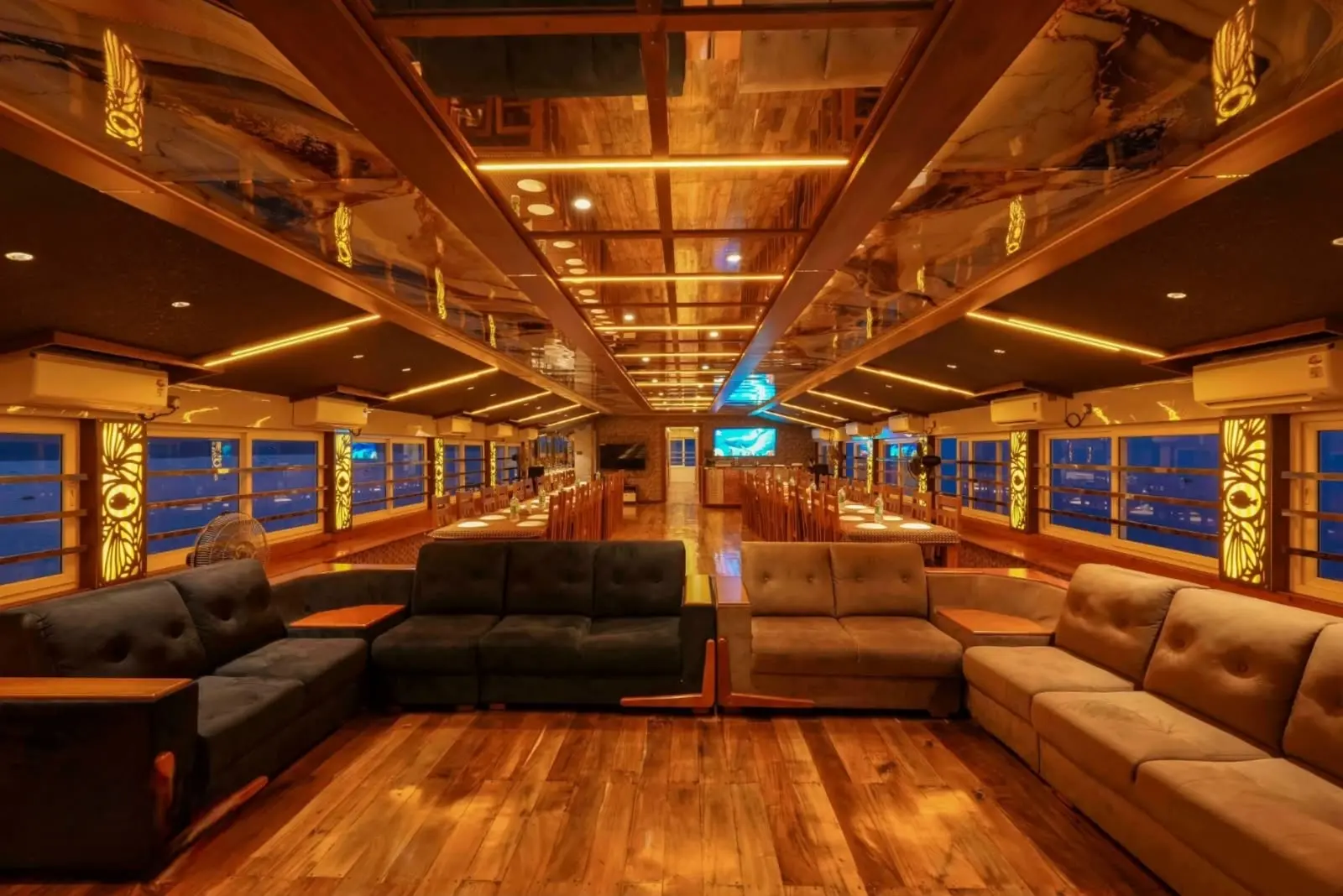 Luxury houseboat lounge and dining hall lit up in the evening