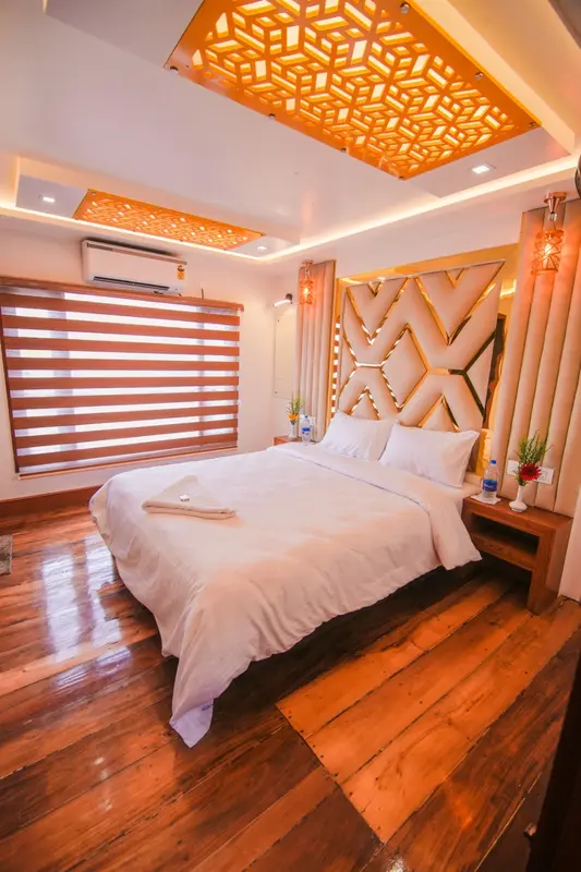 Premium houseboat bedroom with upholstered headboard and lattice ceiling